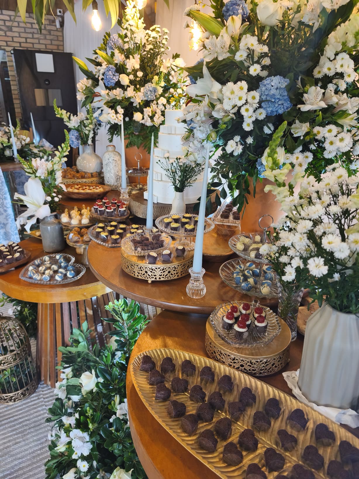 Mesa de doces finos com flores brancas e azuis